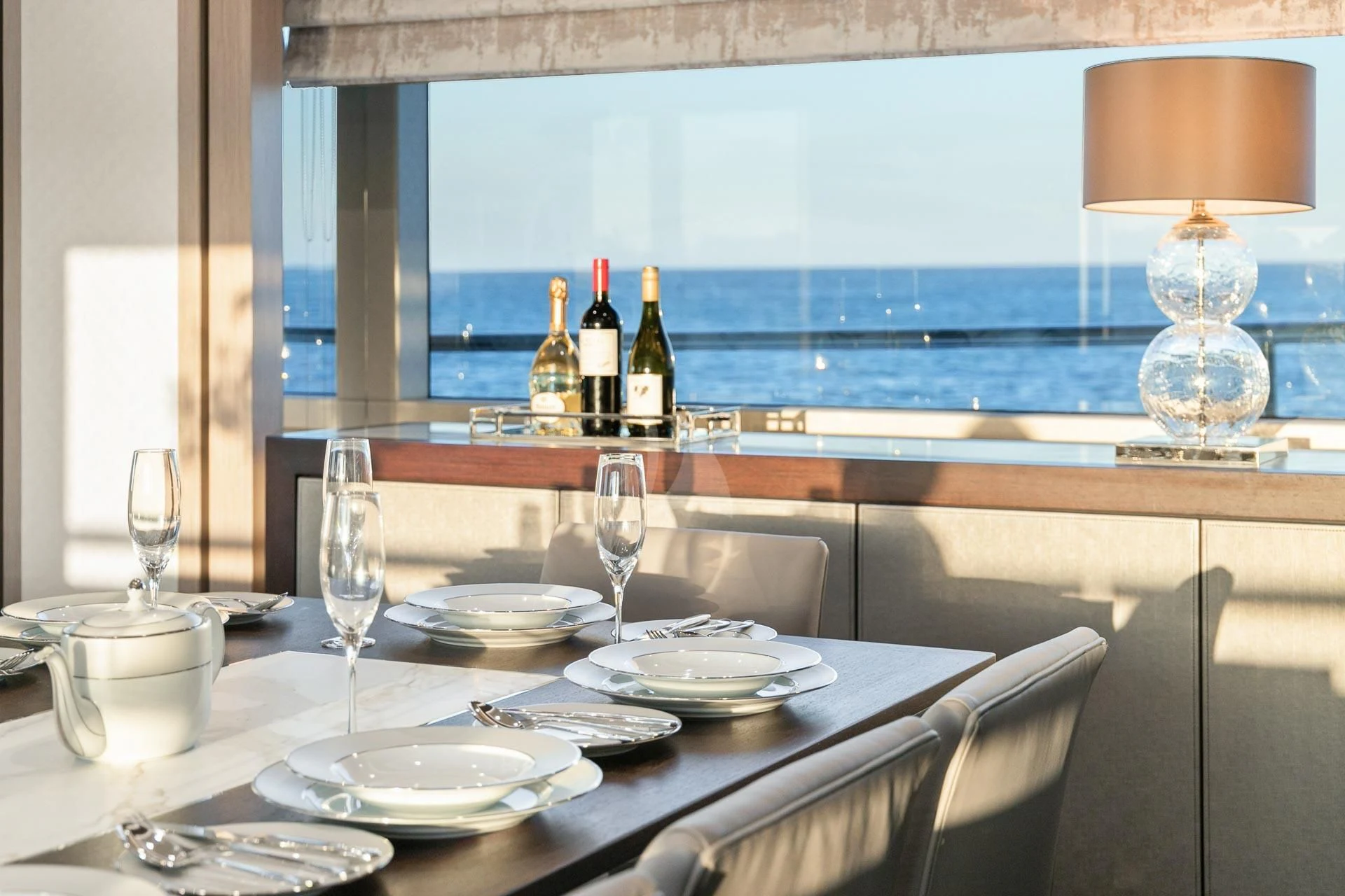 a table with plates and wine bottles aboard SUNSET Yacht for Sale