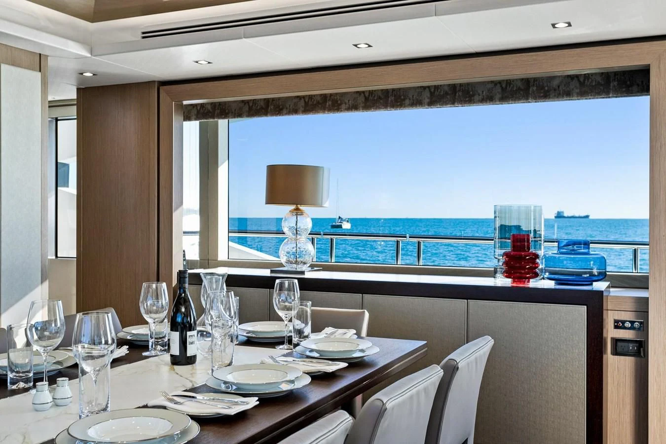 a table with plates and wine glasses aboard SUNSET Yacht for Sale