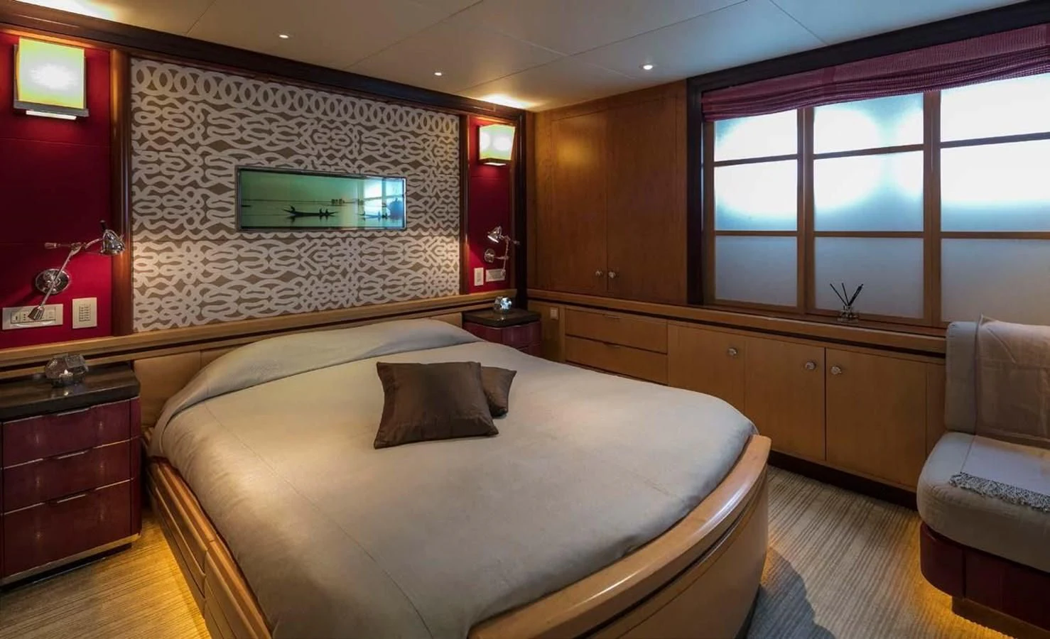 a bedroom with a bed and a chair aboard PEGASUS Yacht for Charter
