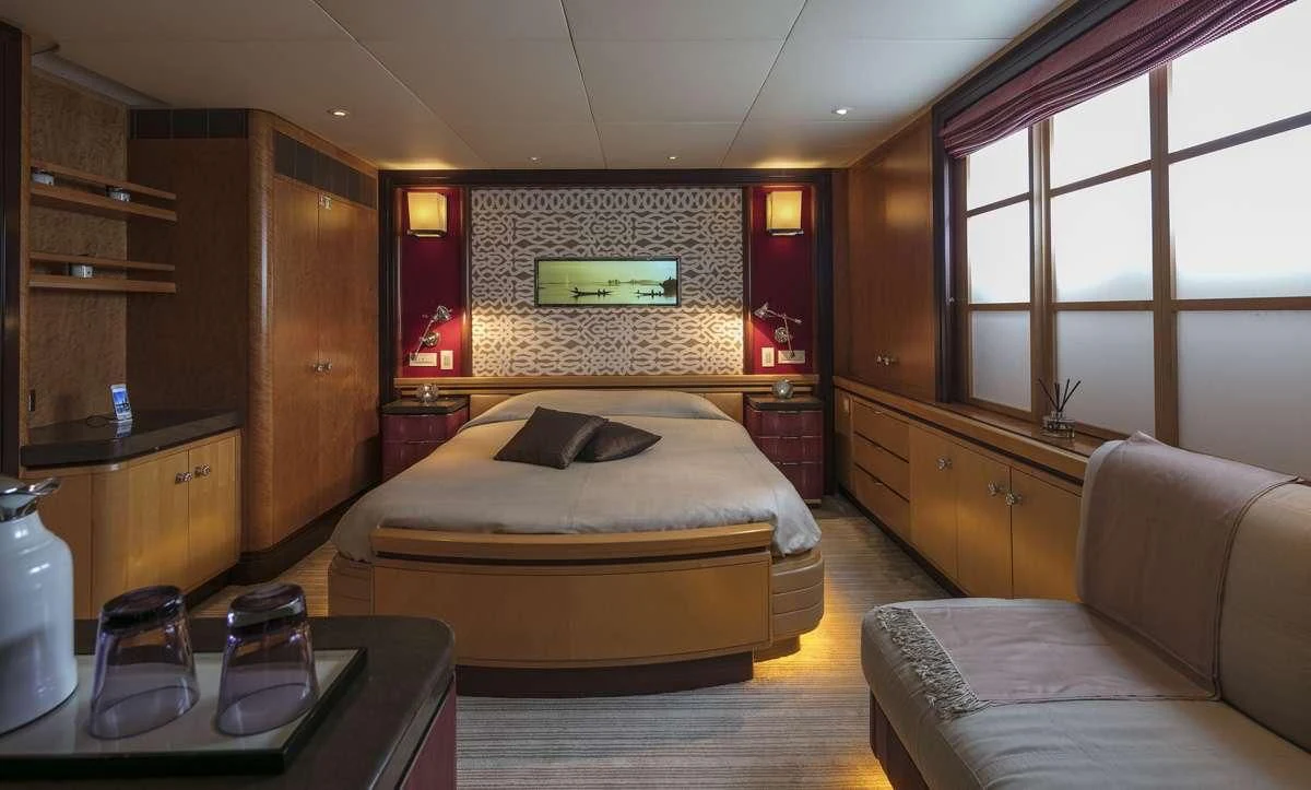 a bedroom with a bed and a table aboard PEGASUS Yacht for Charter
