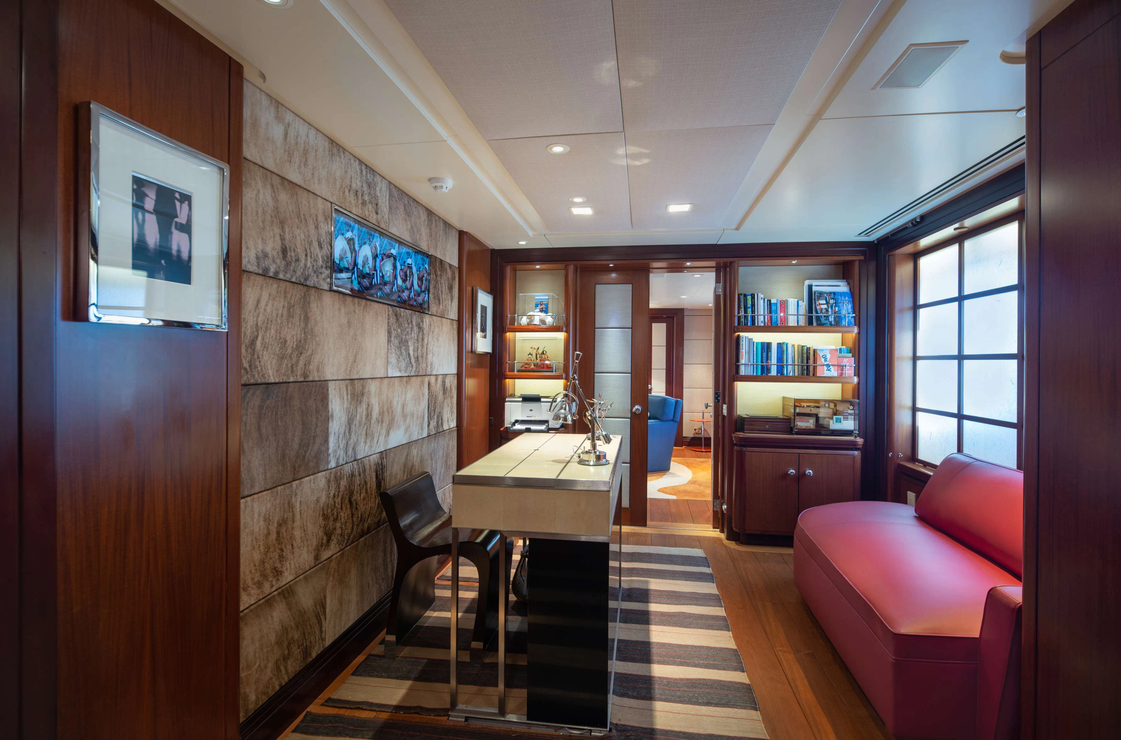 a room with a table chairs and a bookcase aboard PEGASUS Yacht for Charter