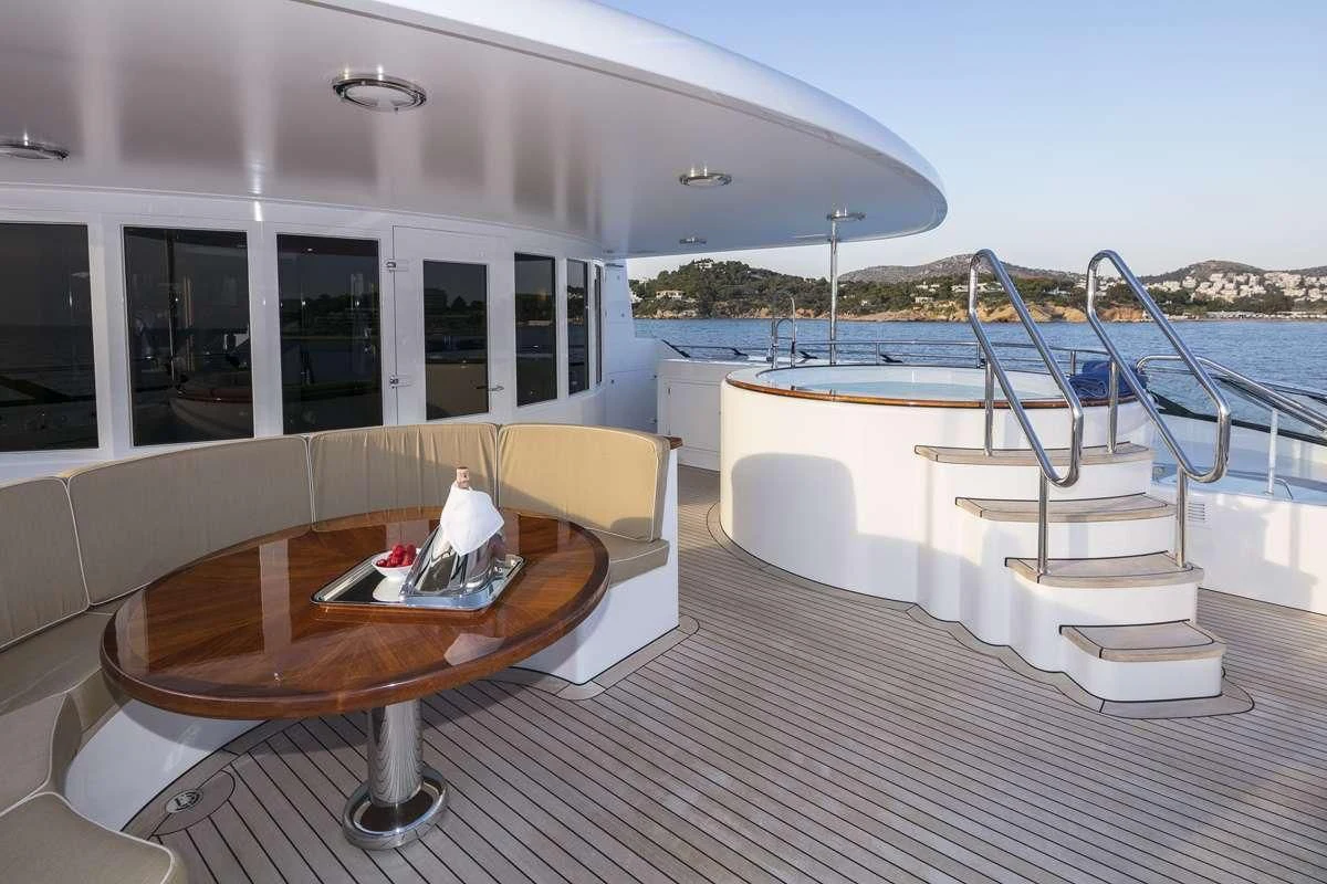 a deck with a table and chairs on it aboard PEGASUS Yacht for Charter