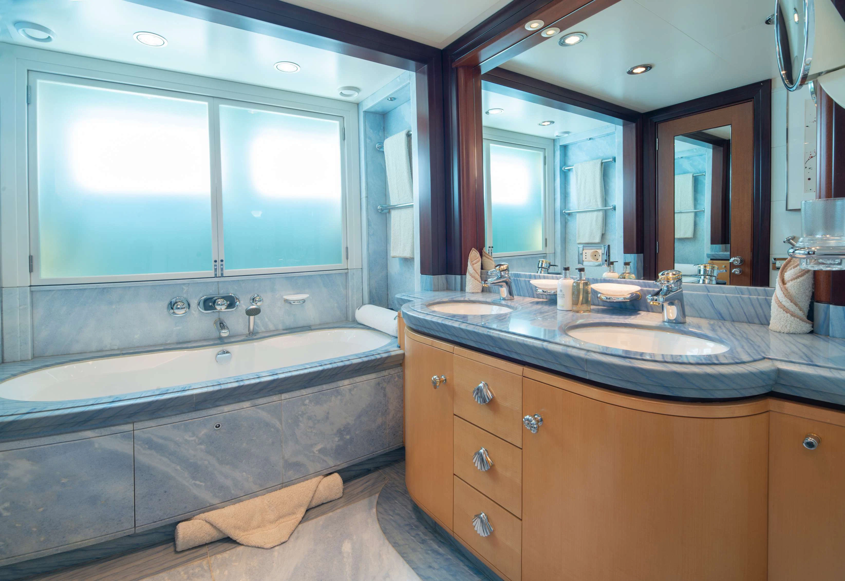 a bathroom with a tub sink and a large mirror aboard PEGASUS Yacht for Charter