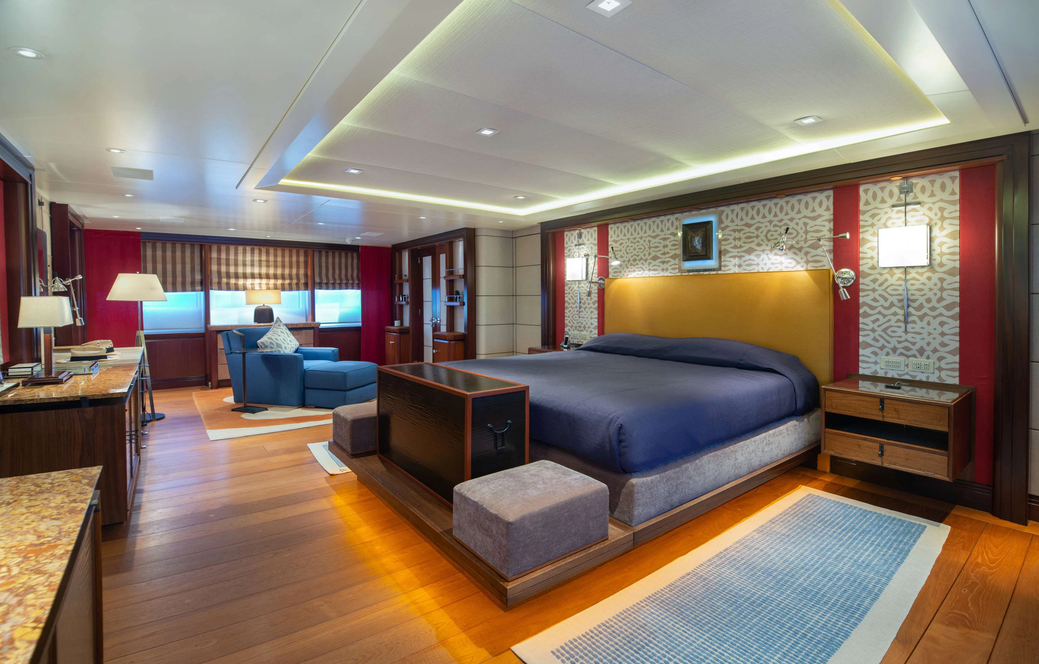 a large living room with a blue couch and a large blue bed aboard PEGASUS Yacht for Charter