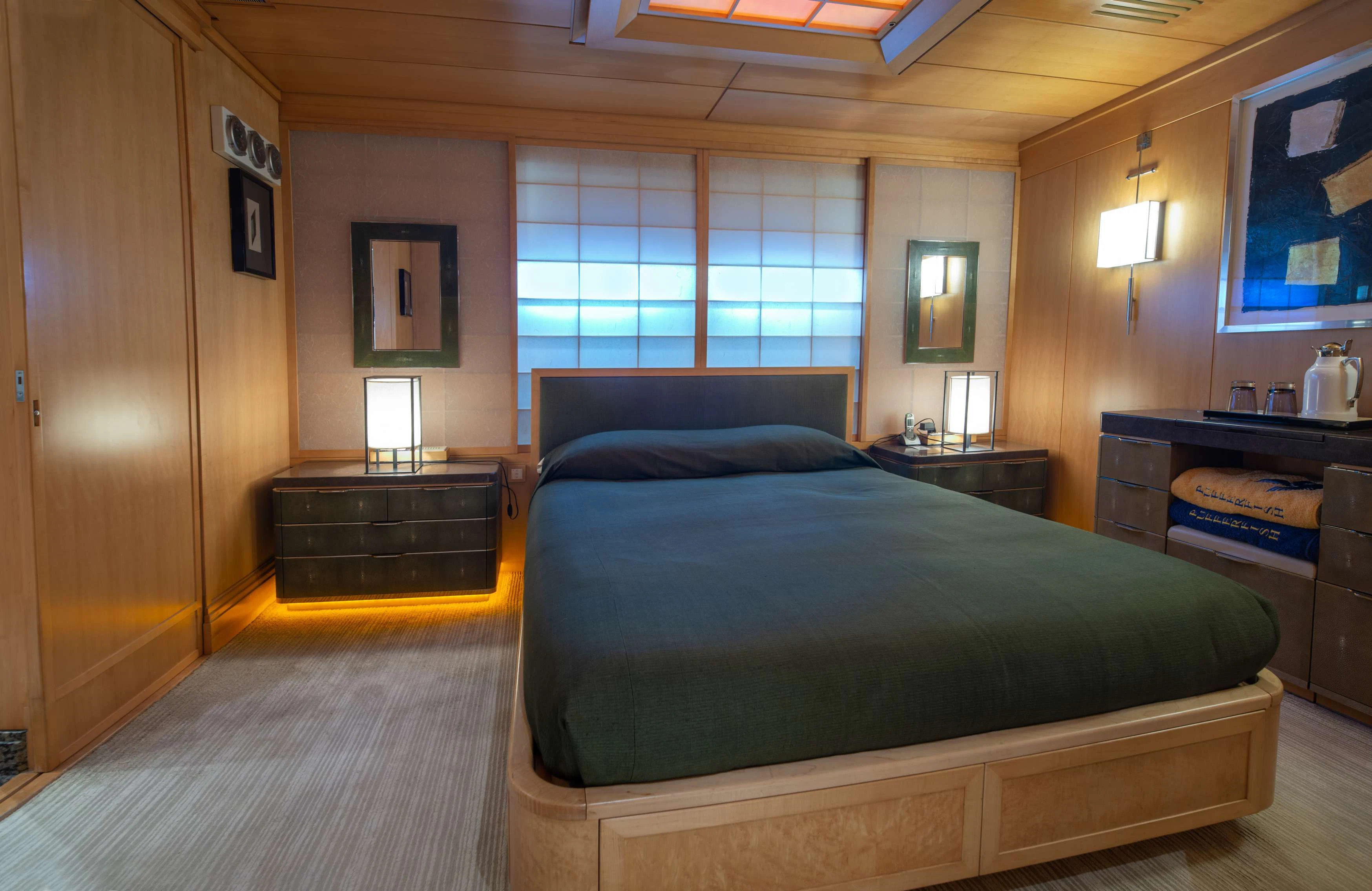a bedroom with a bed and a desk aboard PEGASUS Yacht for Charter