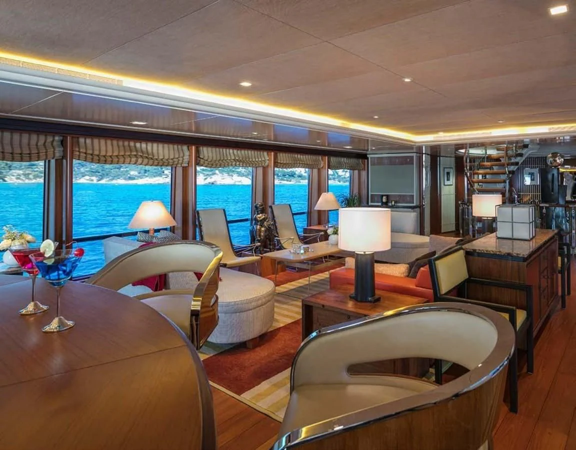 a room with a table chairs and a window with a view of the city aboard PEGASUS Yacht for Charter