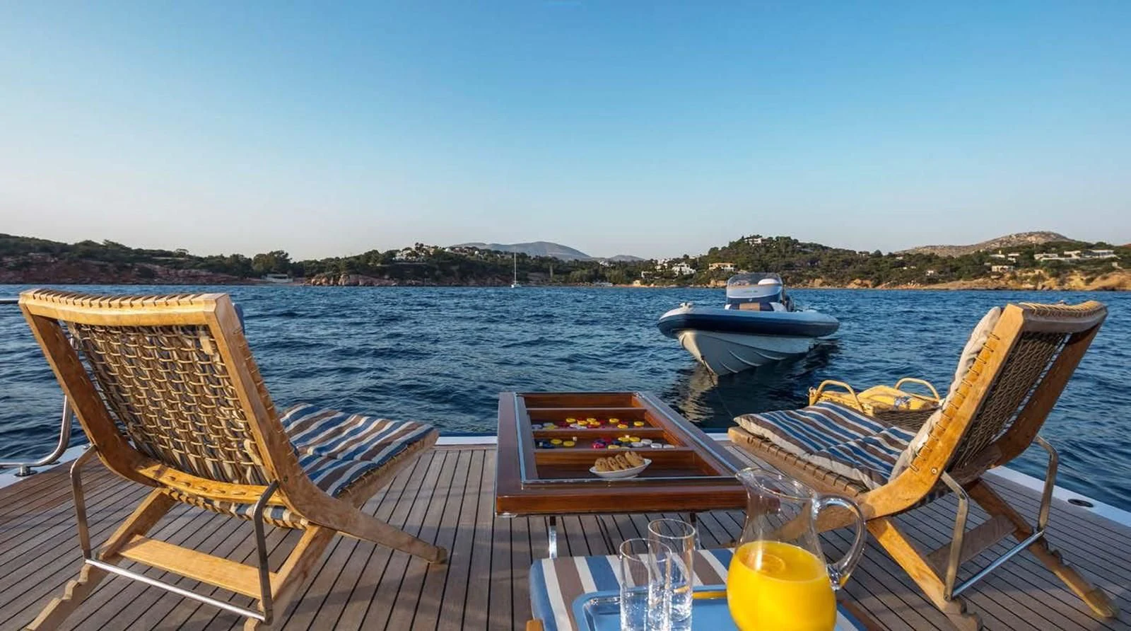 a deck with chairs and a boat on it aboard PEGASUS Yacht for Charter