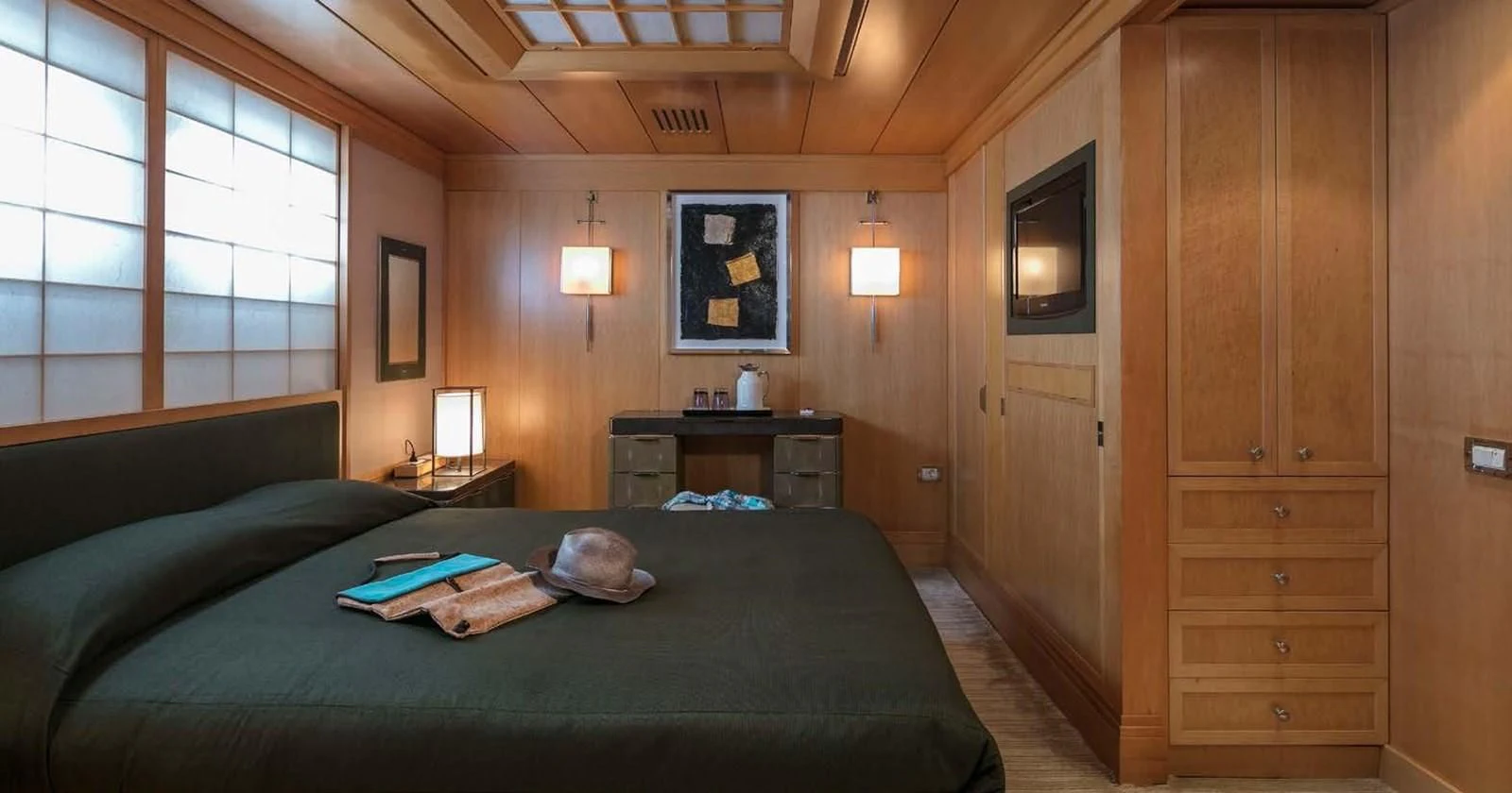 a bedroom with a bed and a desk aboard PEGASUS Yacht for Charter