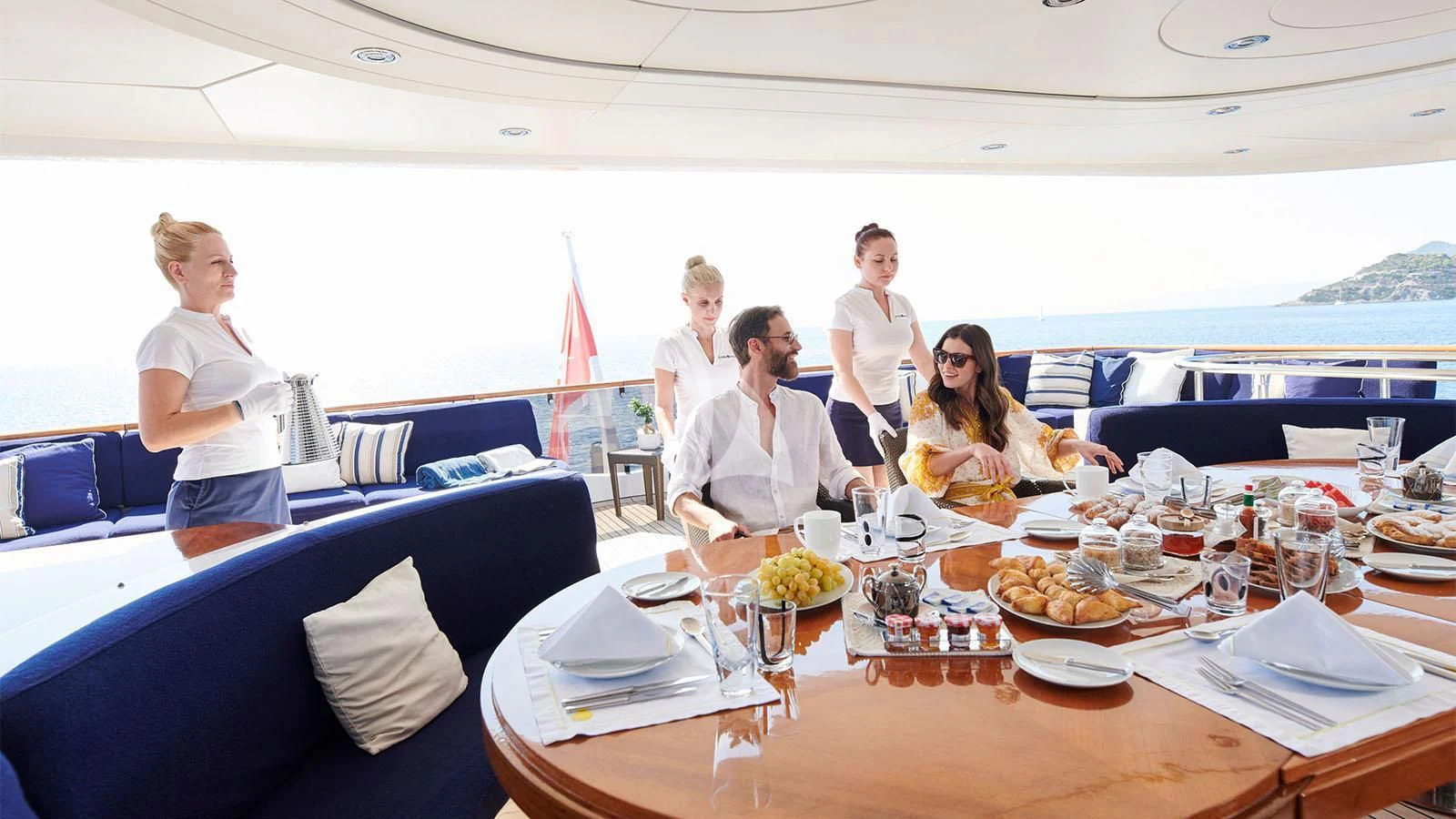 a group of people sitting around a table with food on it aboard RARE FIND Yacht for Charter