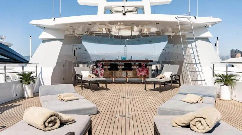 a large white yacht with a lounge area and a table and chairs aboard RARE FIND Yacht for Charter