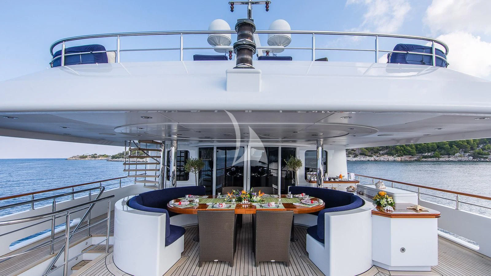 a large white ship with a table and chairs on a deck aboard RARE FIND Yacht for Charter