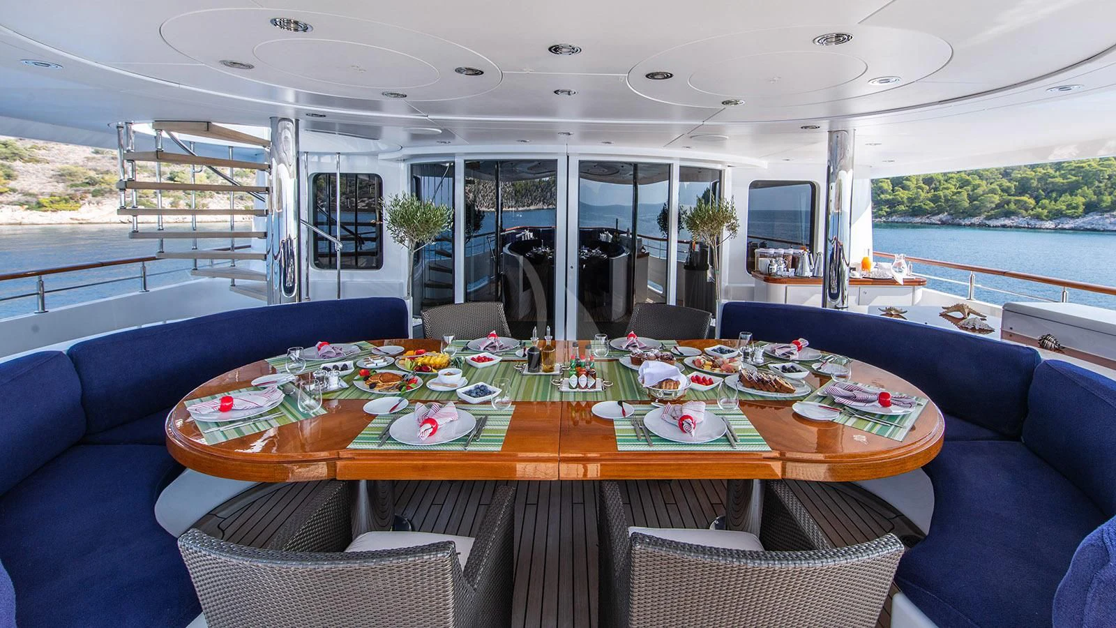 a table with plates and chairs on it aboard RARE FIND Yacht for Charter