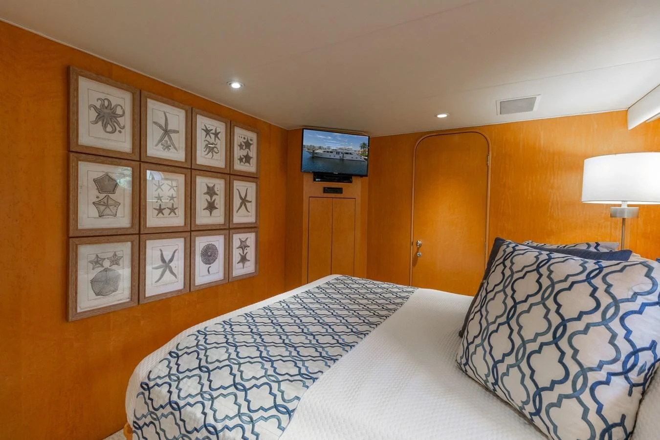 a bedroom with a bed and a lamp aboard IMPULSE Yacht for Sale