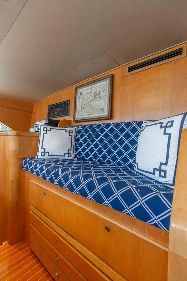a bed with blue and white sheets aboard IMPULSE Yacht for Sale