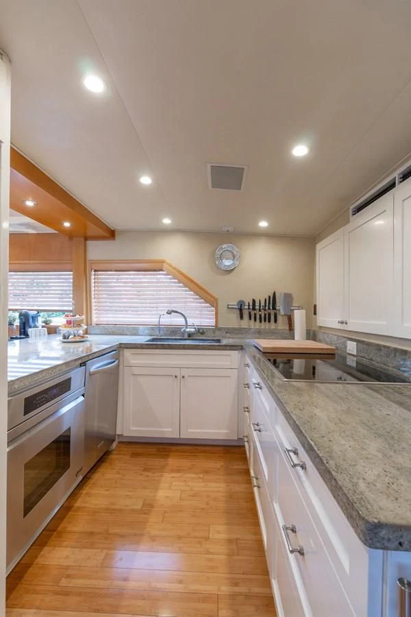 a kitchen with white cabinets aboard IMPULSE Yacht for Sale