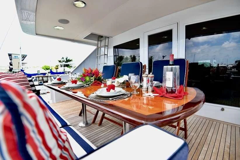 a dining table with a view of the ocean aboard IMPULSE Yacht for Sale