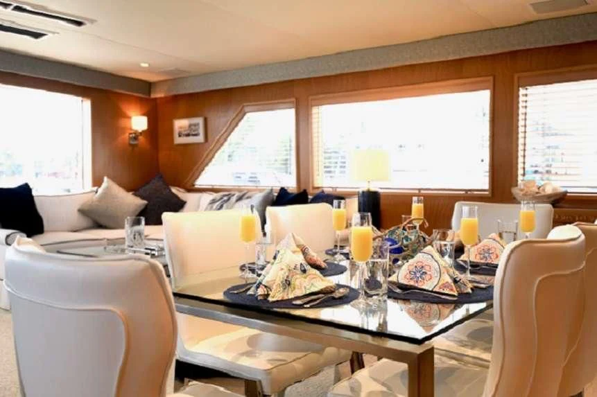 a dining table with a plate of food and glasses on it aboard IMPULSE Yacht for Sale