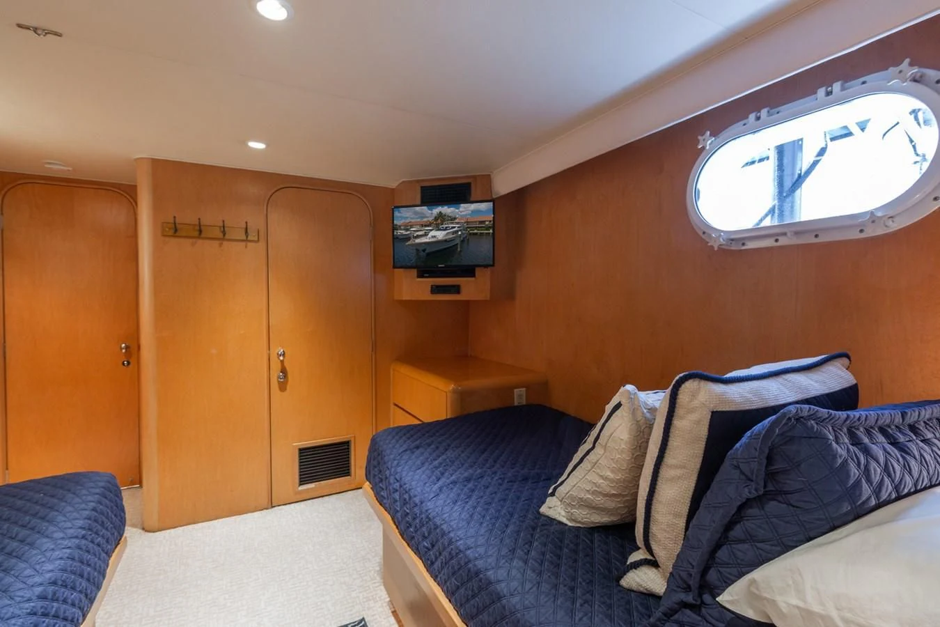 a bedroom with a blue couch and a wood door aboard IMPULSE Yacht for Sale