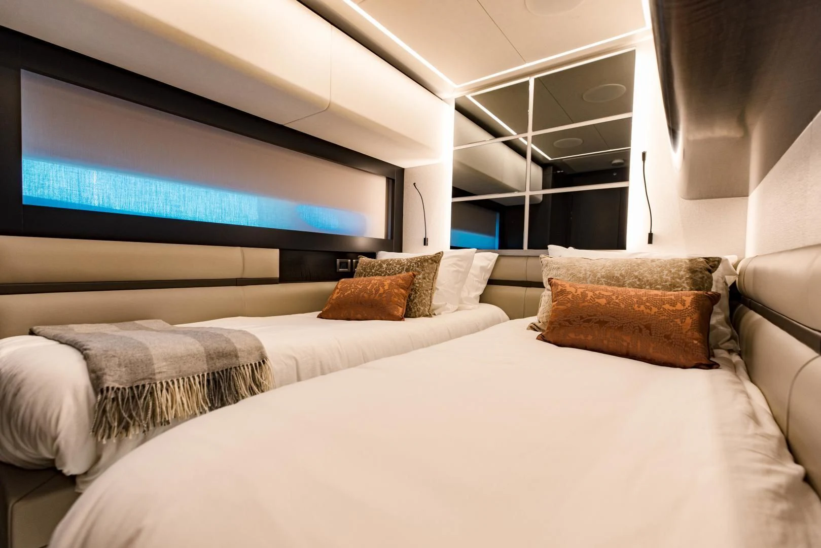 a bed with pillows and a tv on the wall aboard STALLION Yacht for Sale