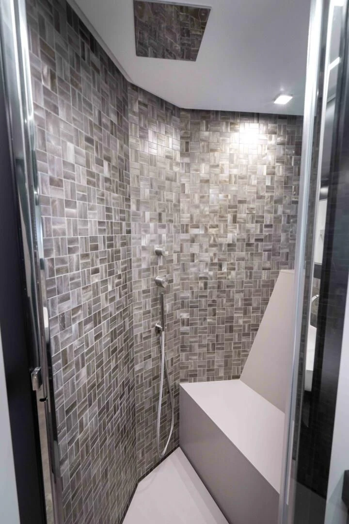a bathroom with a tile wall aboard STALLION Yacht for Sale