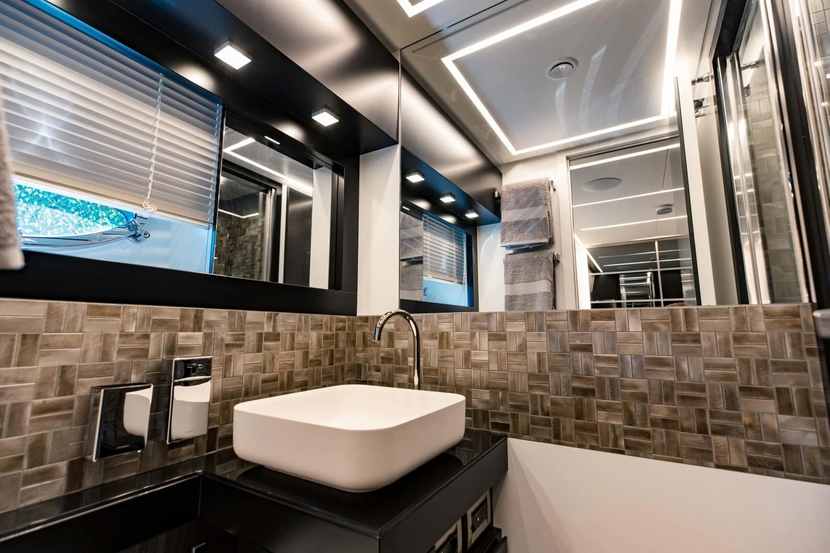 a bathroom with a sink and a large mirror aboard STALLION Yacht for Sale