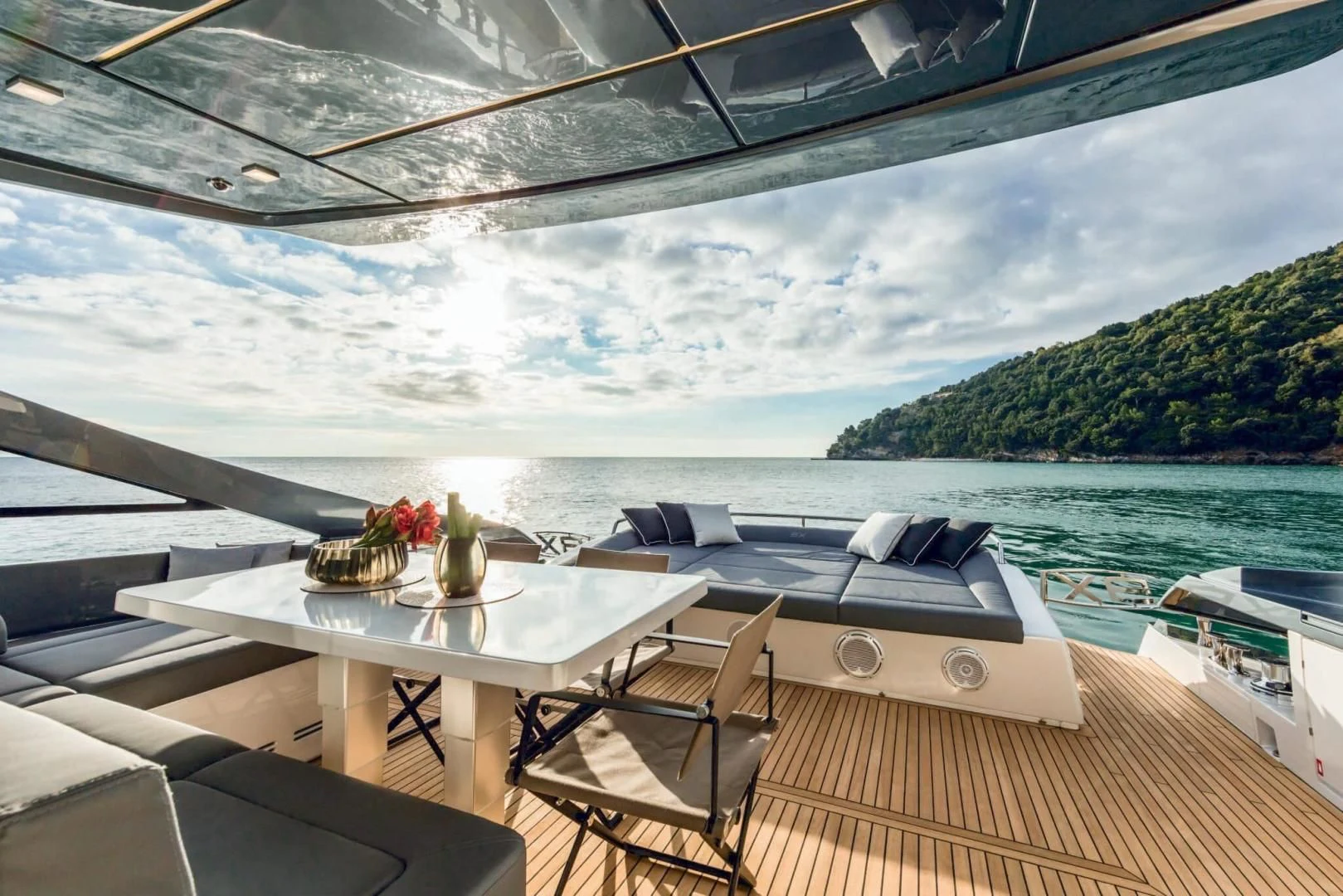 a deck with a table and chairs on it and a body of water in the background aboard STALLION Yacht for Sale