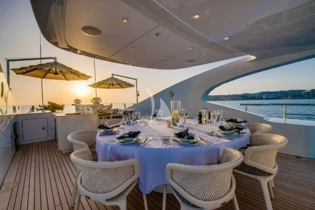 a table set for a meal on a deck aboard AZIZA Yacht for Sale