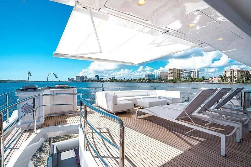 a large white lounge chair on a deck overlooking a city aboard BLACKJACK Yacht for Sale