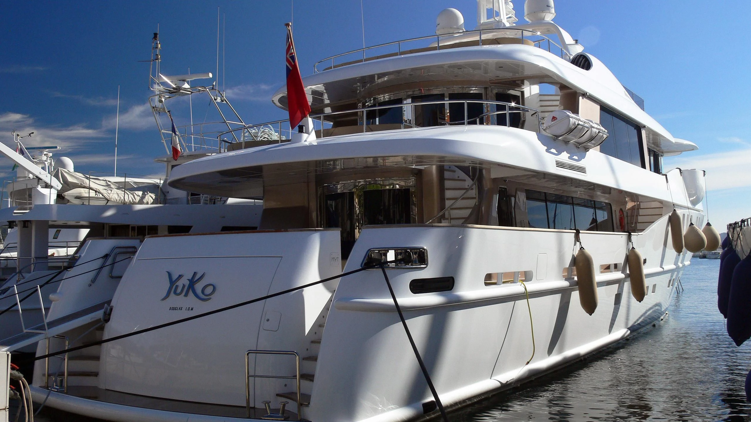 a white boat with a red and black flag on it aboard MY SAGA Yacht for Sale
