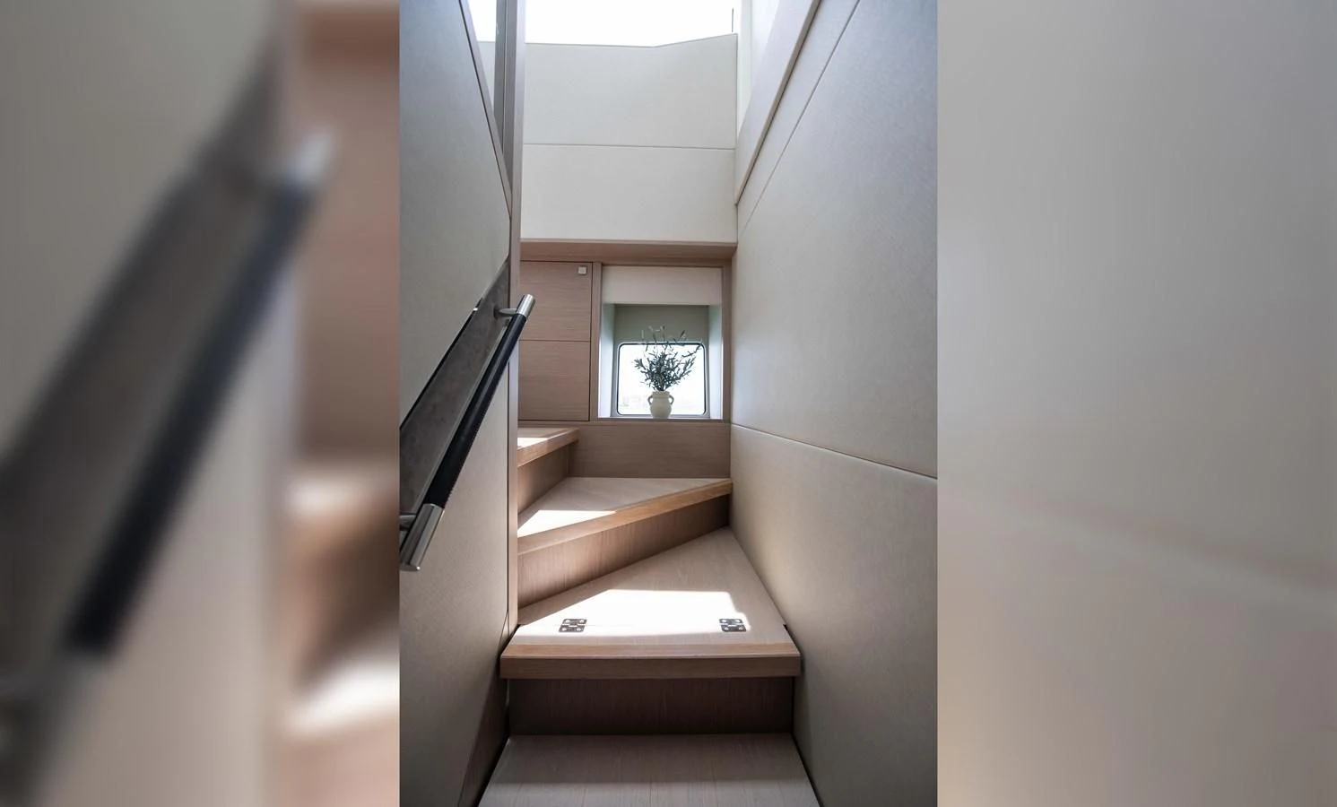 a staircase with a plant on the side aboard MILAMO Yacht for Sale