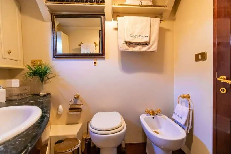 a bathroom with a toilet sink and a mirror aboard D.P. MONITOR Yacht for Sale