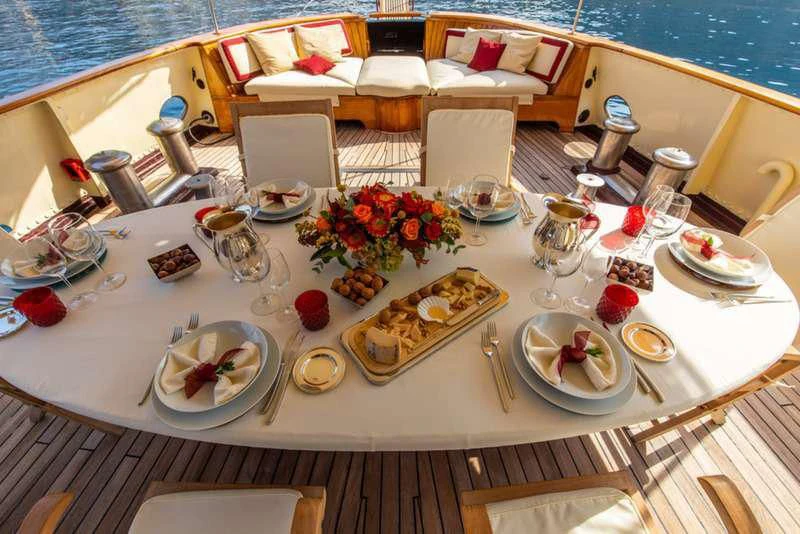 a table with plates and glasses aboard D.P. MONITOR Yacht for Sale