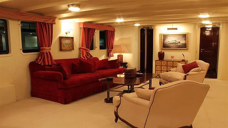 a living room with red couches aboard D.P. MONITOR Yacht for Sale