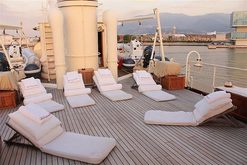 a deck with a view of a marina with boats and a city in the background aboard D.P. MONITOR Yacht for Sale