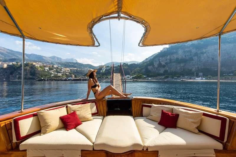 a person sitting on a couch under a yellow umbrella aboard D.P. MONITOR Yacht for Sale