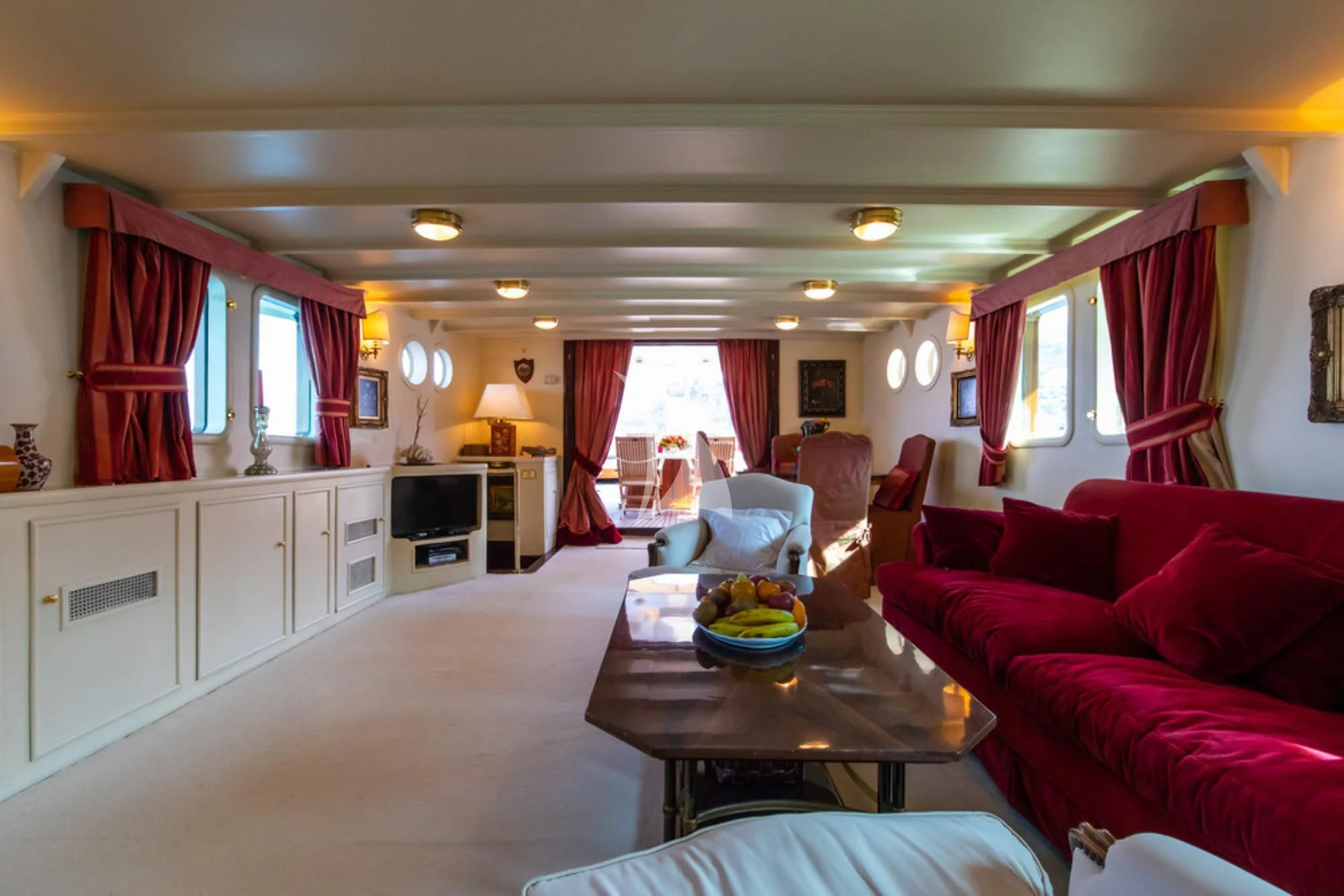 a living room with red couches aboard D.P. MONITOR Yacht for Sale