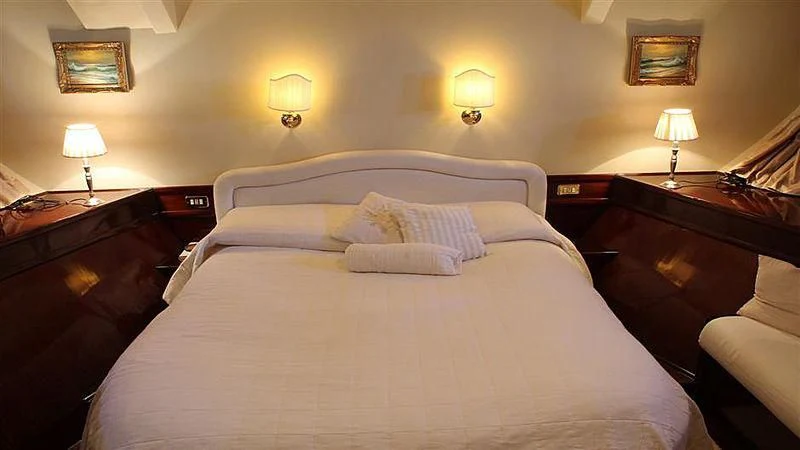a bed with lamps on either side aboard D.P. MONITOR Yacht for Sale
