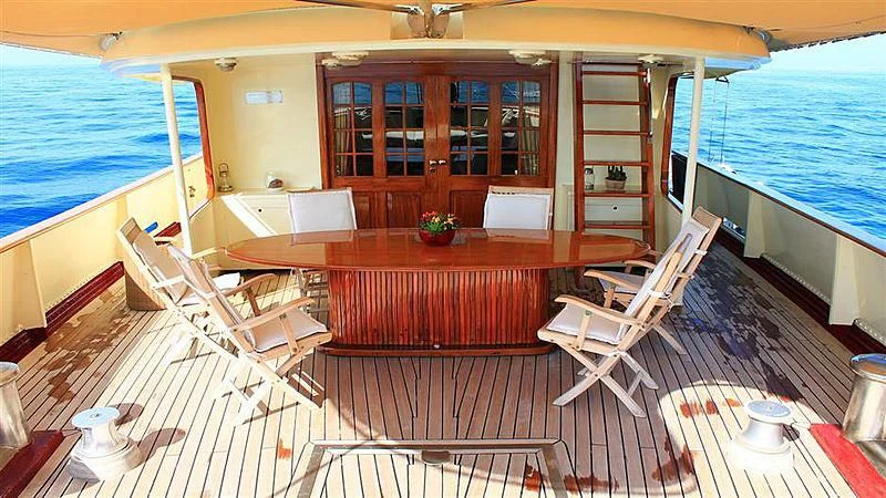 a room with a table chairs and a bed aboard D.P. MONITOR Yacht for Sale