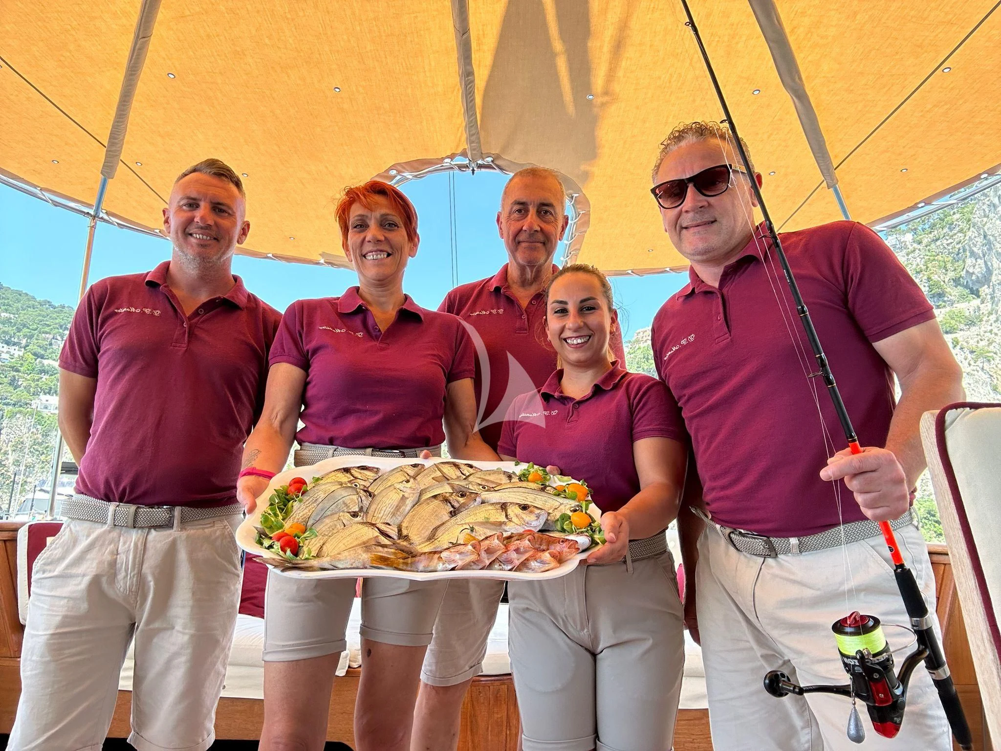 a group of people holding a pizza aboard D.P. MONITOR Yacht for Sale