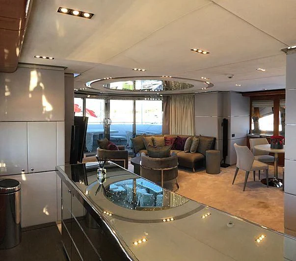 a living room with a large glass table and a large window aboard BLISS Yacht for Sale