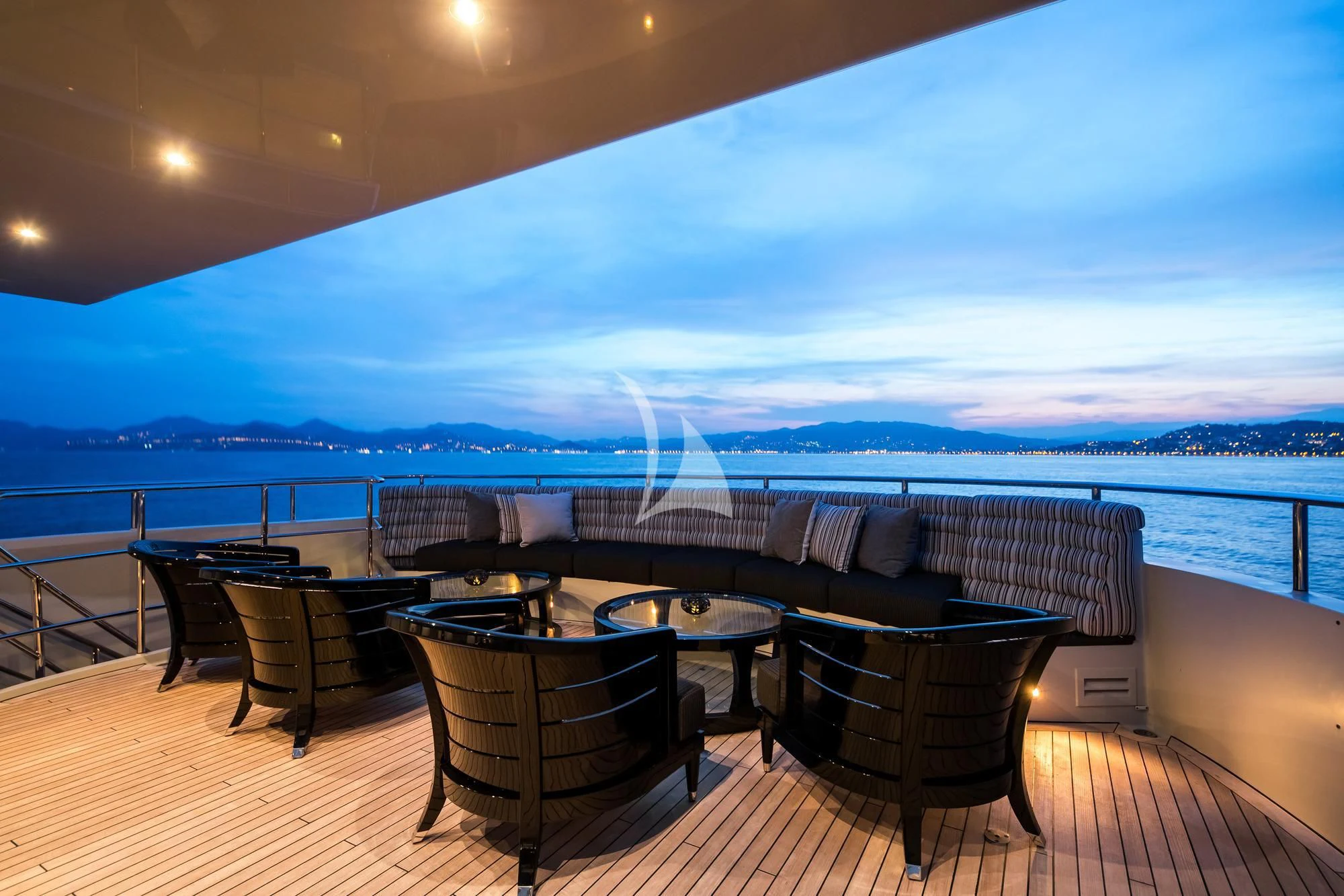 a table and chairs on a deck overlooking a large body of water aboard BLISS Yacht for Sale