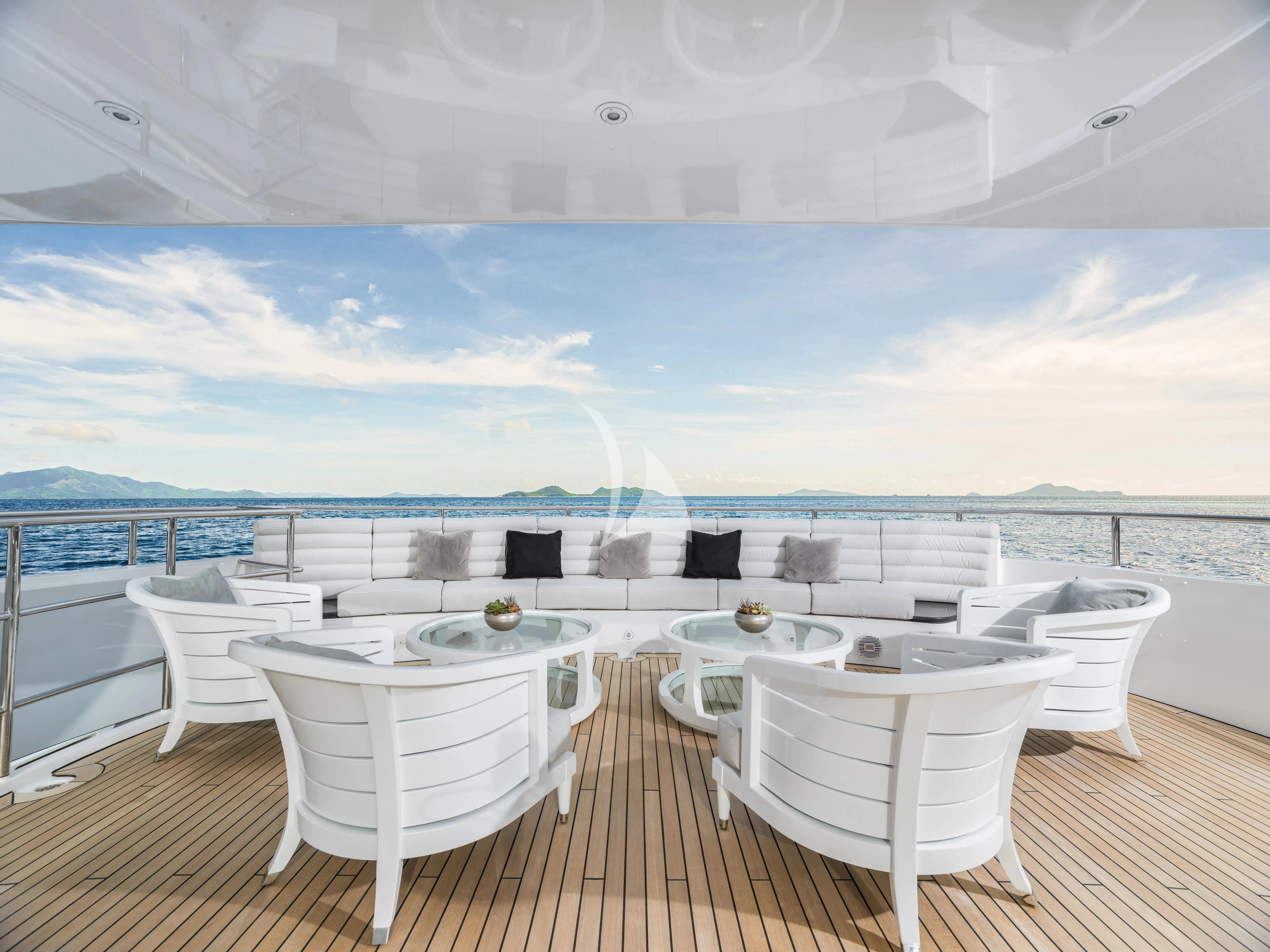 a large white lounge chair on a deck overlooking a large body of water aboard BLISS Yacht for Sale