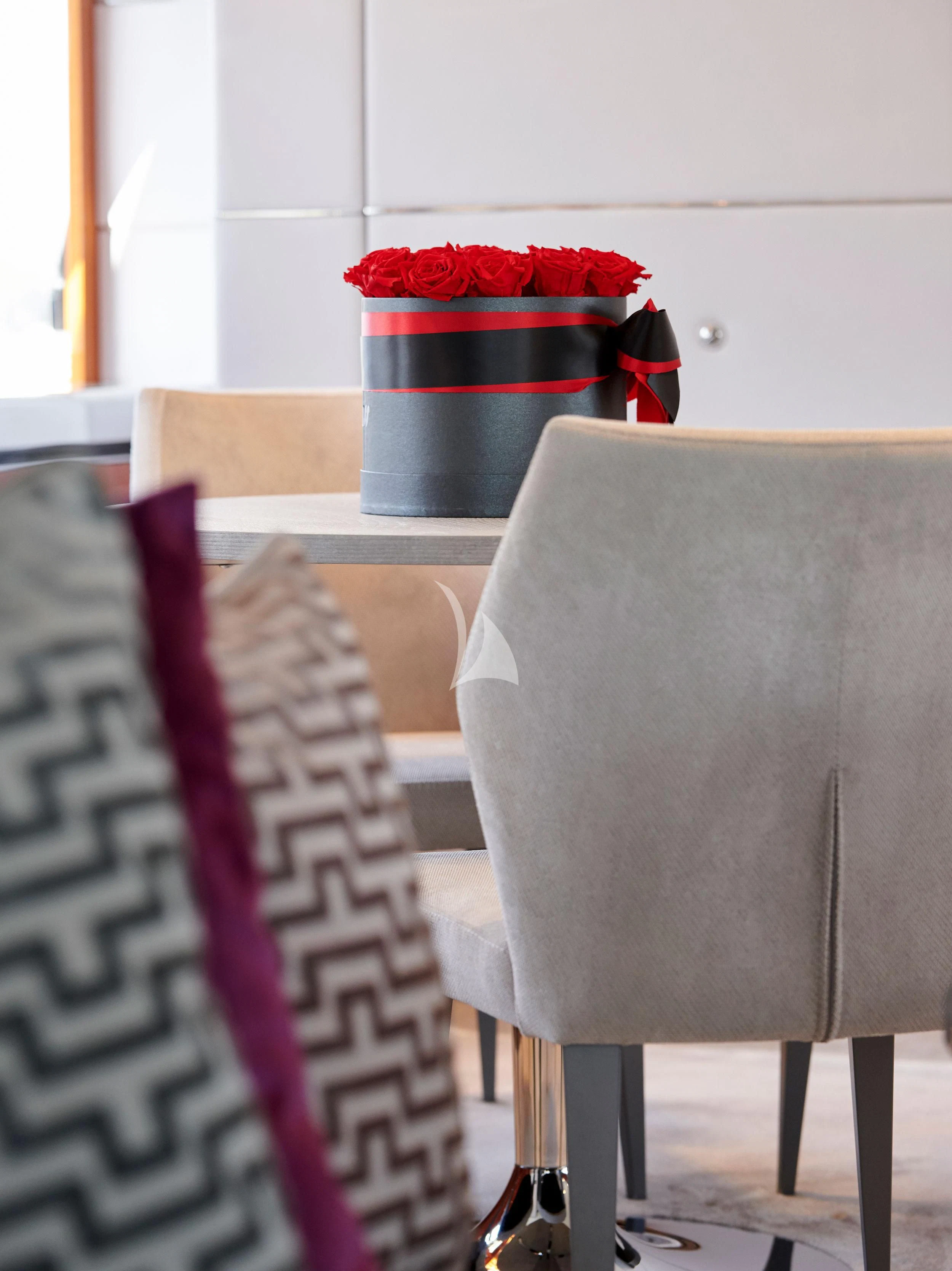 a red and white striped pillow on a chair aboard BLISS Yacht for Sale