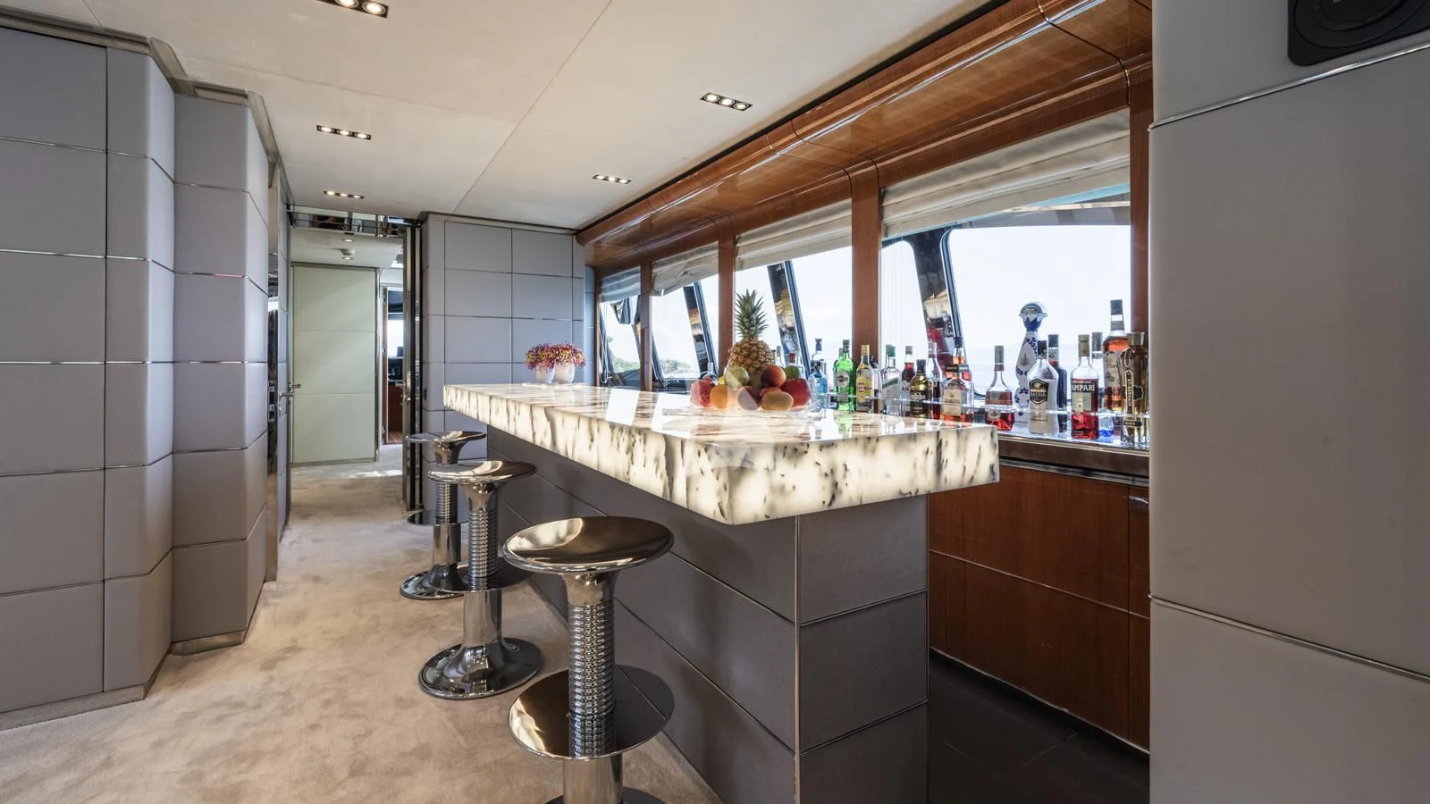 a kitchen with a bar stools and a counter with stools aboard BLISS Yacht for Sale