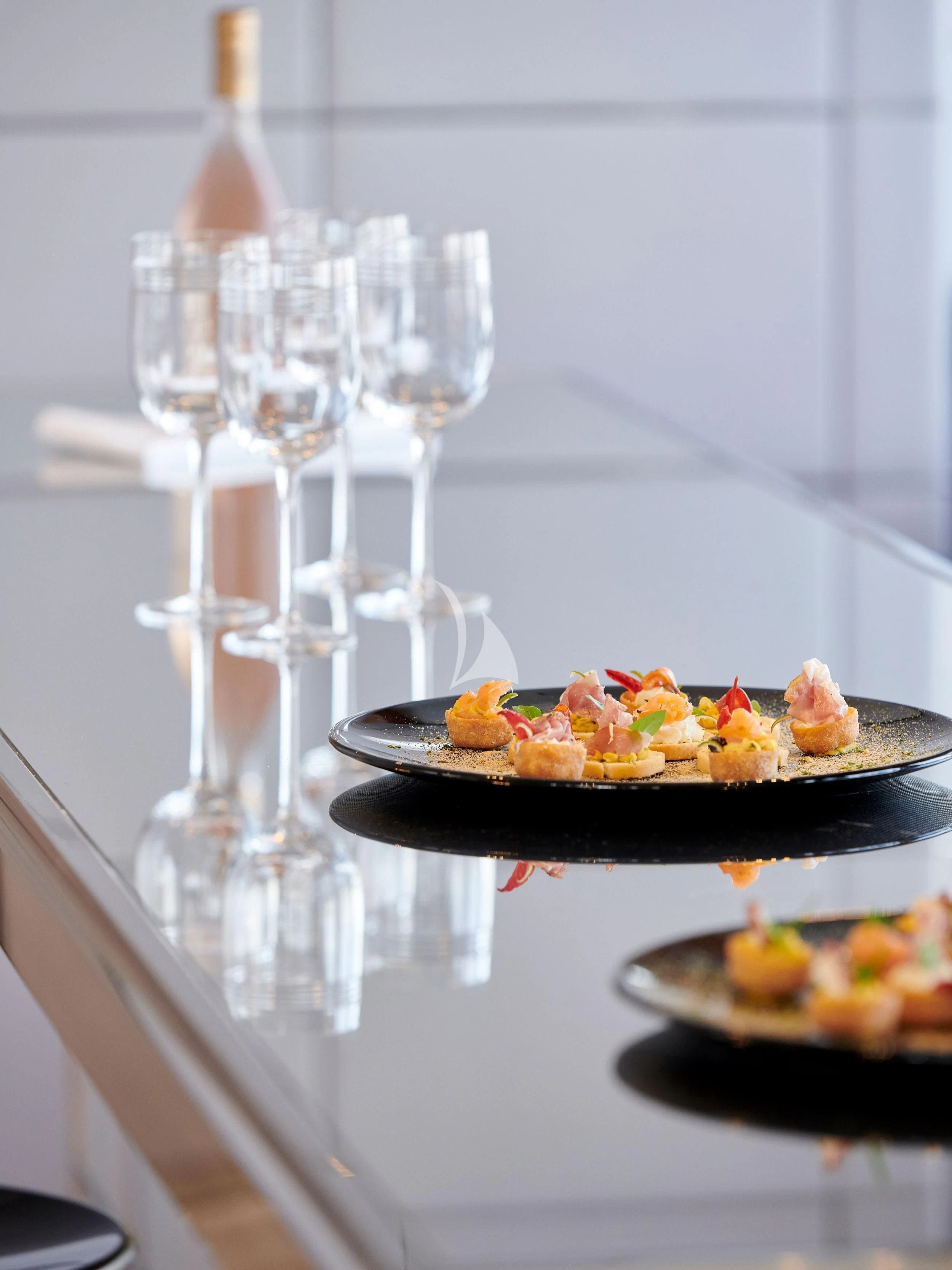 a table with food and wine glasses aboard BLISS Yacht for Sale
