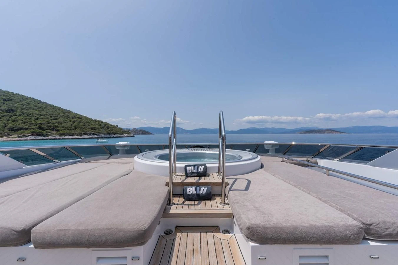 a deck with a boat on it and a body of water in the background aboard BLISS Yacht for Sale