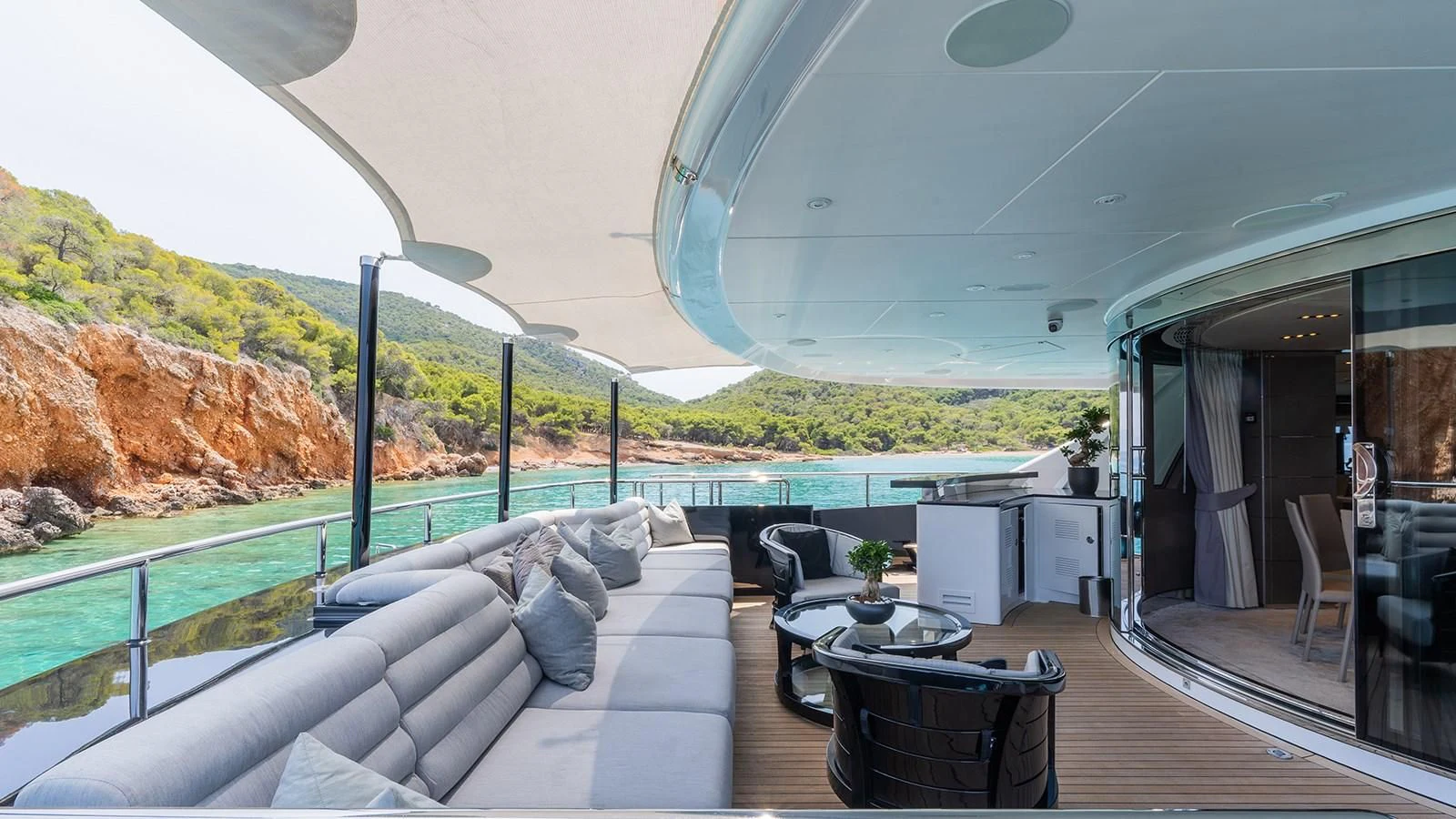 a deck with a view of a lake and mountains aboard BLISS Yacht for Sale