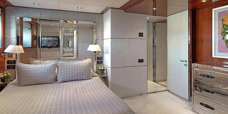 a bedroom with a bed and a desk aboard BLISS Yacht for Sale