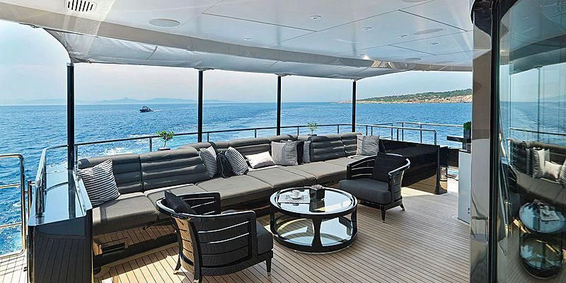a deck with chairs and a table on it aboard BLISS Yacht for Sale