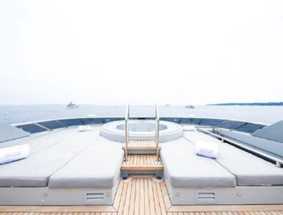 a deck with a railing and a boat on it aboard BLISS Yacht for Sale